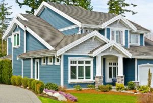 Suburban home with grey asphalt shingle roofing and blue siding